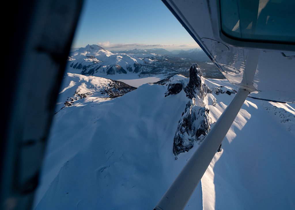 Looking out of an open window in a small airplane directly onto the Black Tusk near Whistler, BC