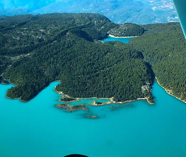 Looking down on the bright turquoise colour of Garibaldi Lake near Squamish and Whistler, BC in summer from a scenic flight plane