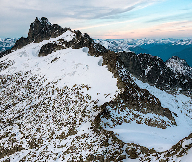 Ridge line of a mountain in the Tantalus Range, Squamish poking through the glacier ice on a summer day