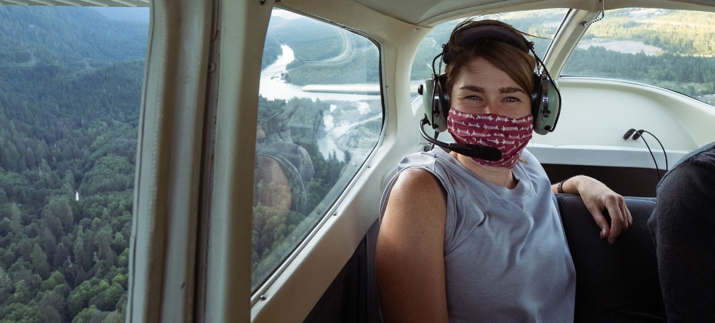 Smiling with a face mask inside aircraft